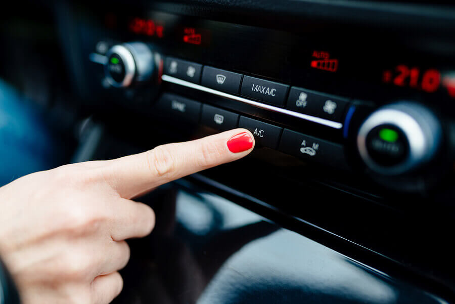 A woman turning on her air conditioning